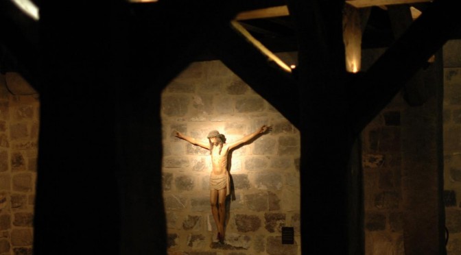 Christ en croix sur un mur de pierre au milieu de poutres